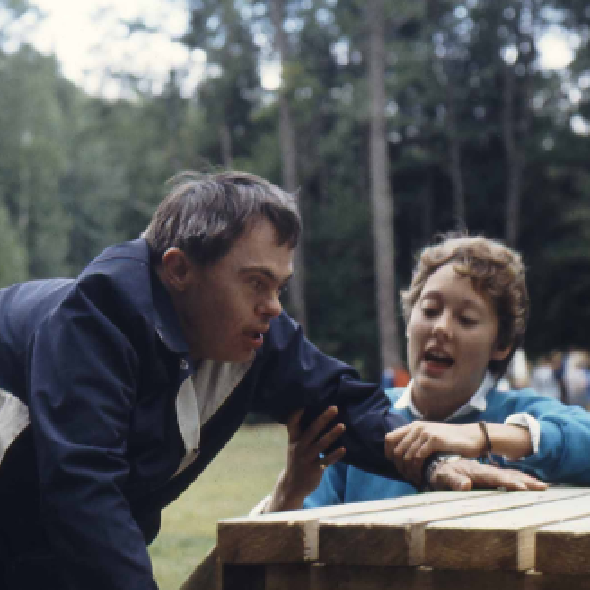 A camper climbs up a playground with support at one of Karis’ first camps in the late 60s.