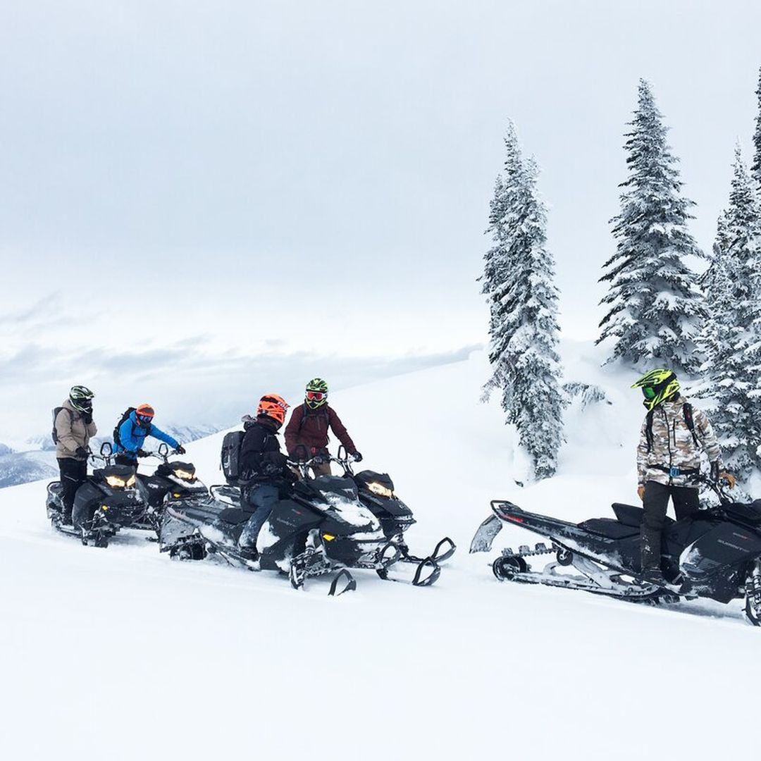 group of five snowmobilers out in the mountains