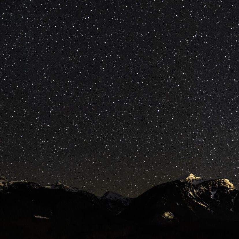 night time stars with mountains highlighted by the moon
