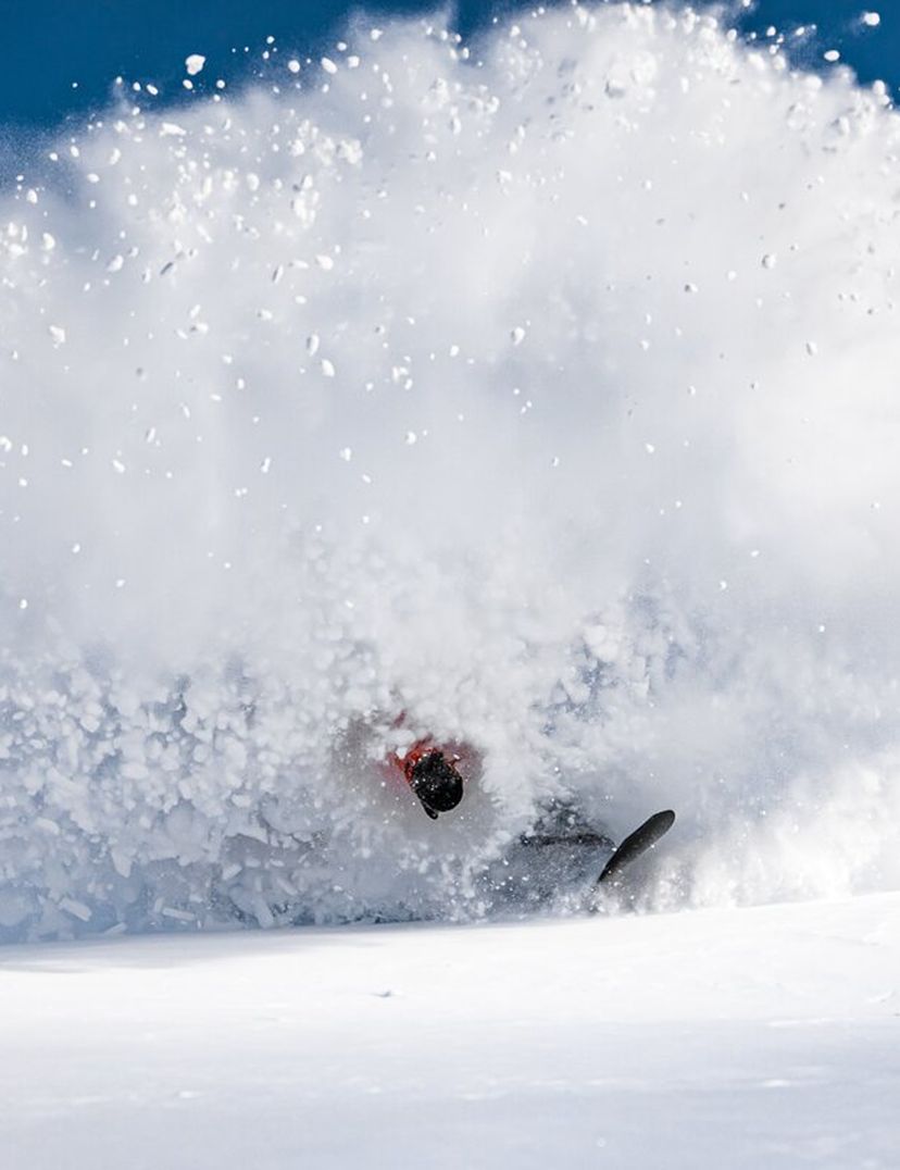 snowboarder slashing pow