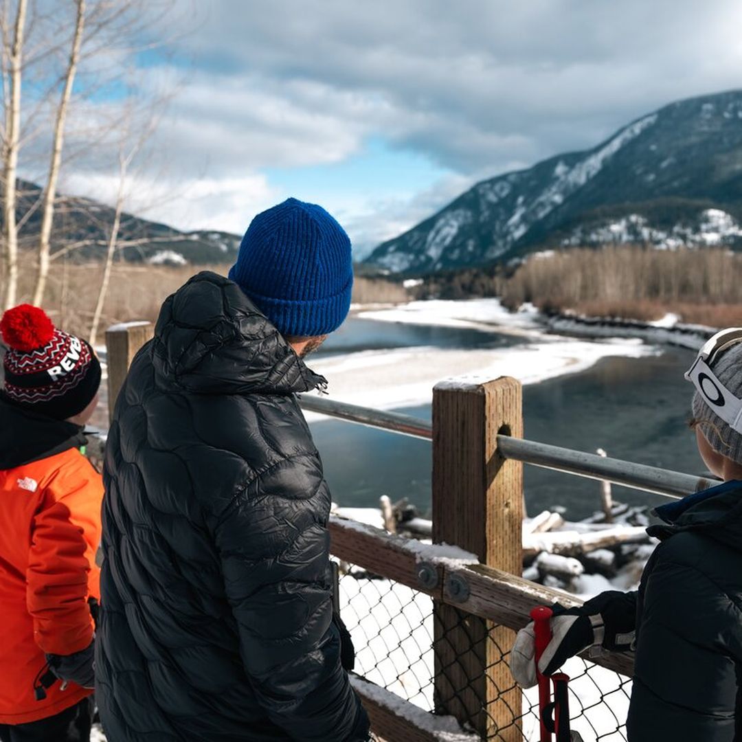 family looking out onto a river in snow
