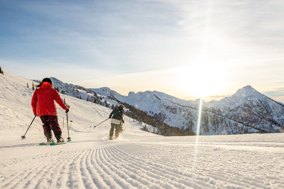 people skiing groomer on sunny day