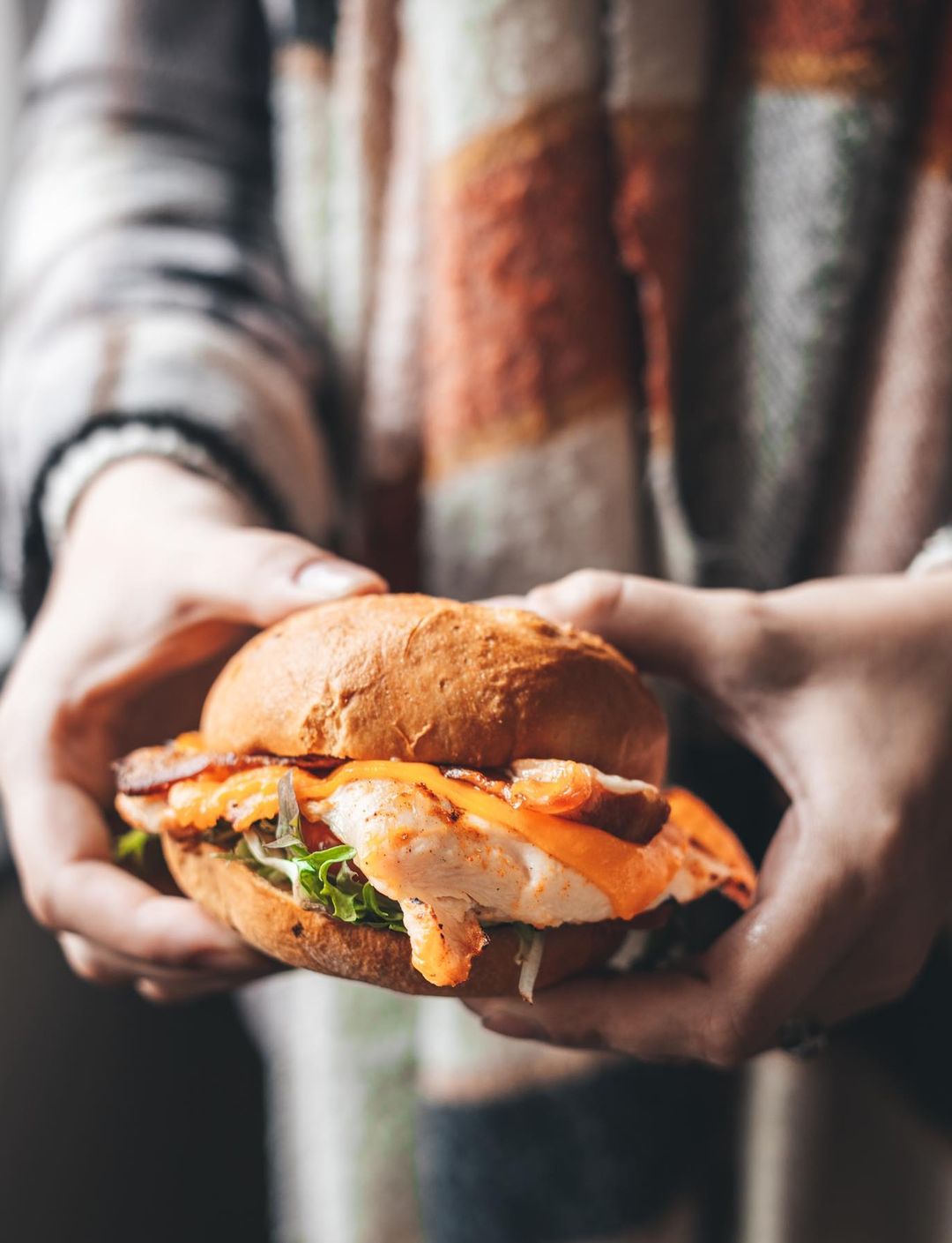 holding chicken sandwich out for photo