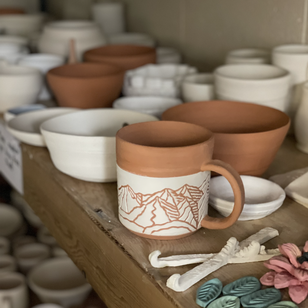 pottery on shelves before going into the kiln