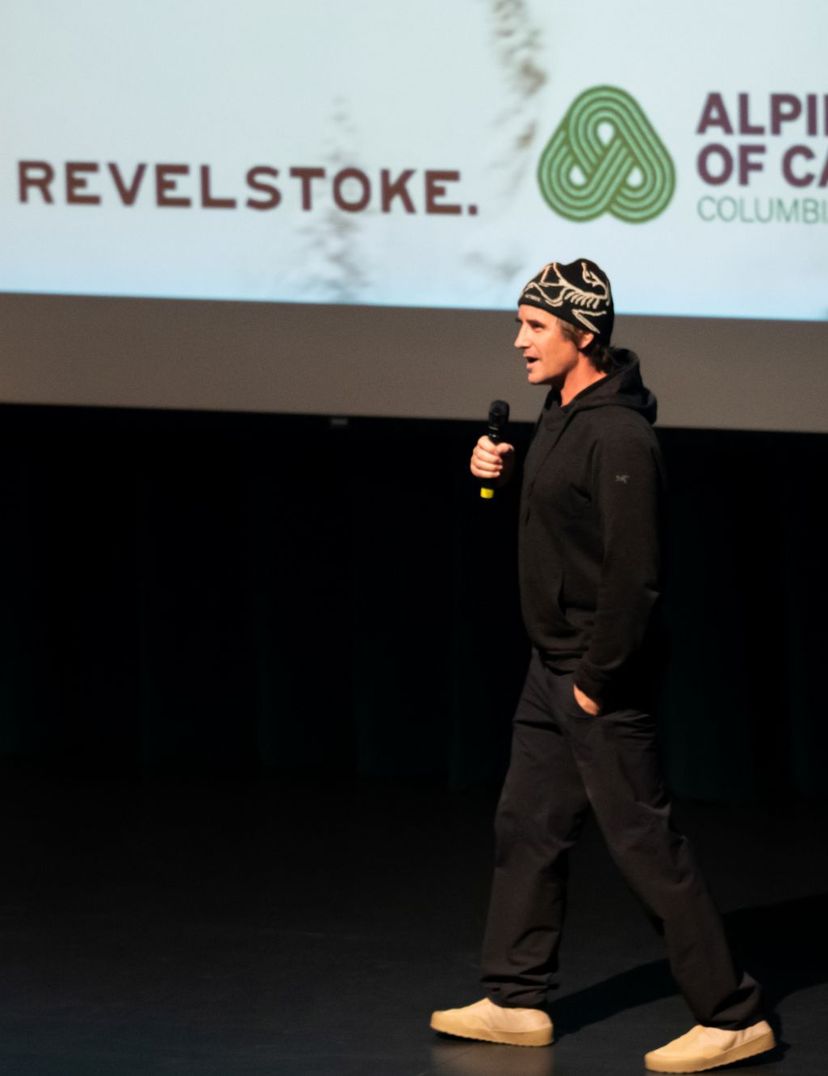 man speaking on stage at film night
