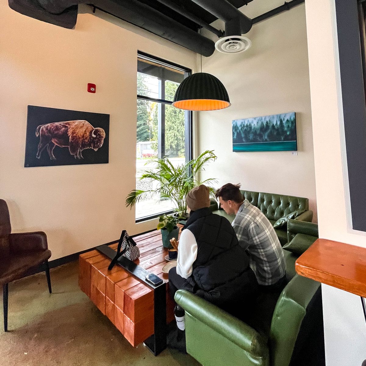 two people sitting on couches in corner at bakery