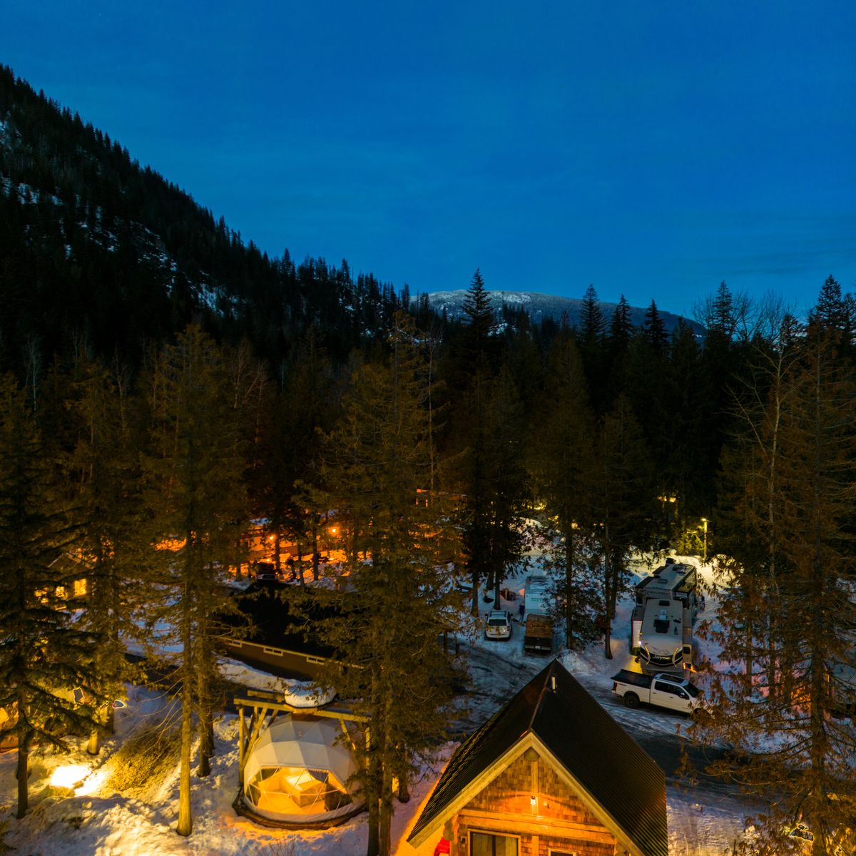 cabin geodome and trailer parking at local campground in snowy winter scene