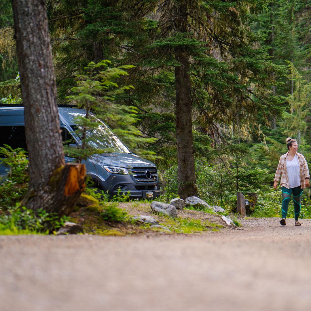 dog on leash with couple walking through campground