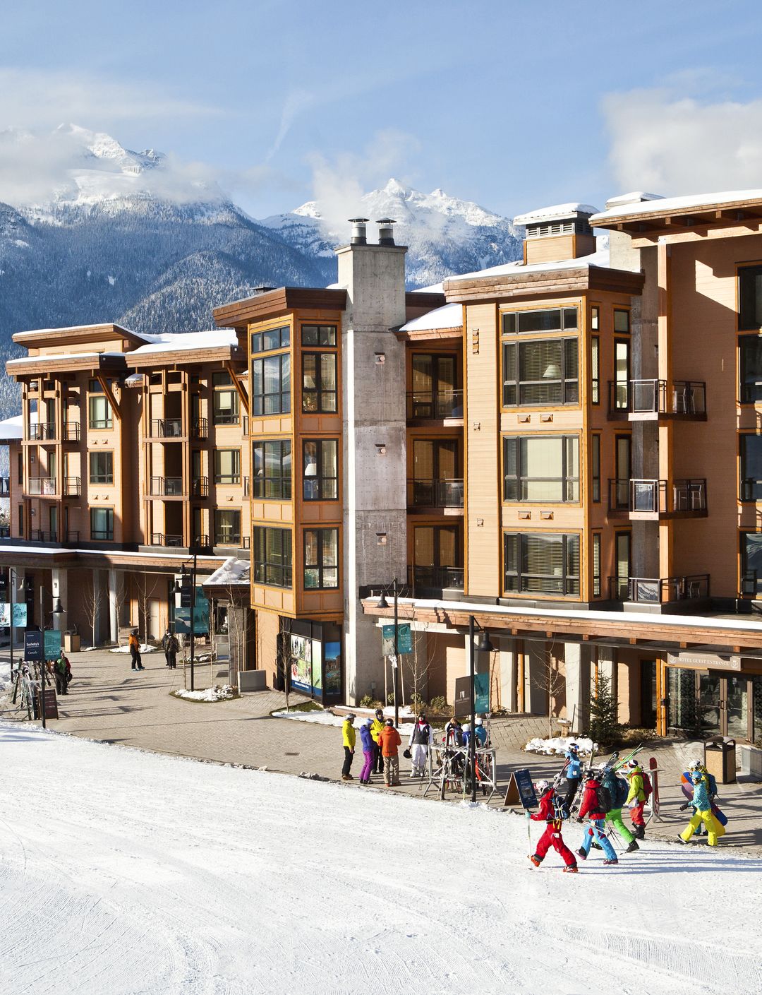 slopeside accommodation hotel with people in ski gear walking by