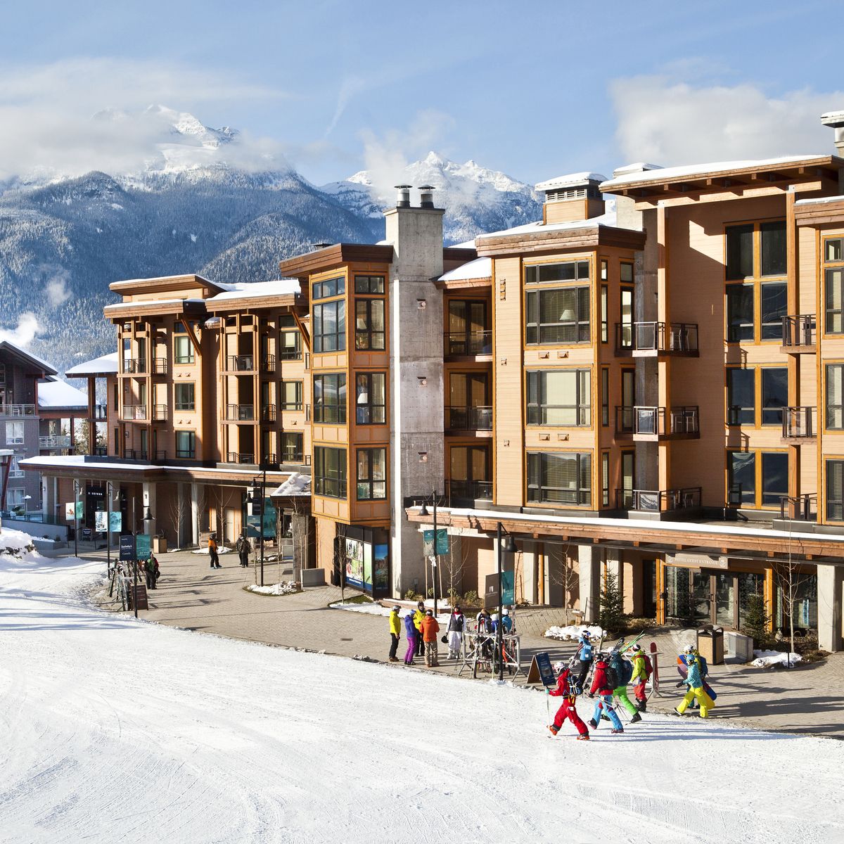 slopeside accommodation hotel with people in ski gear walking by