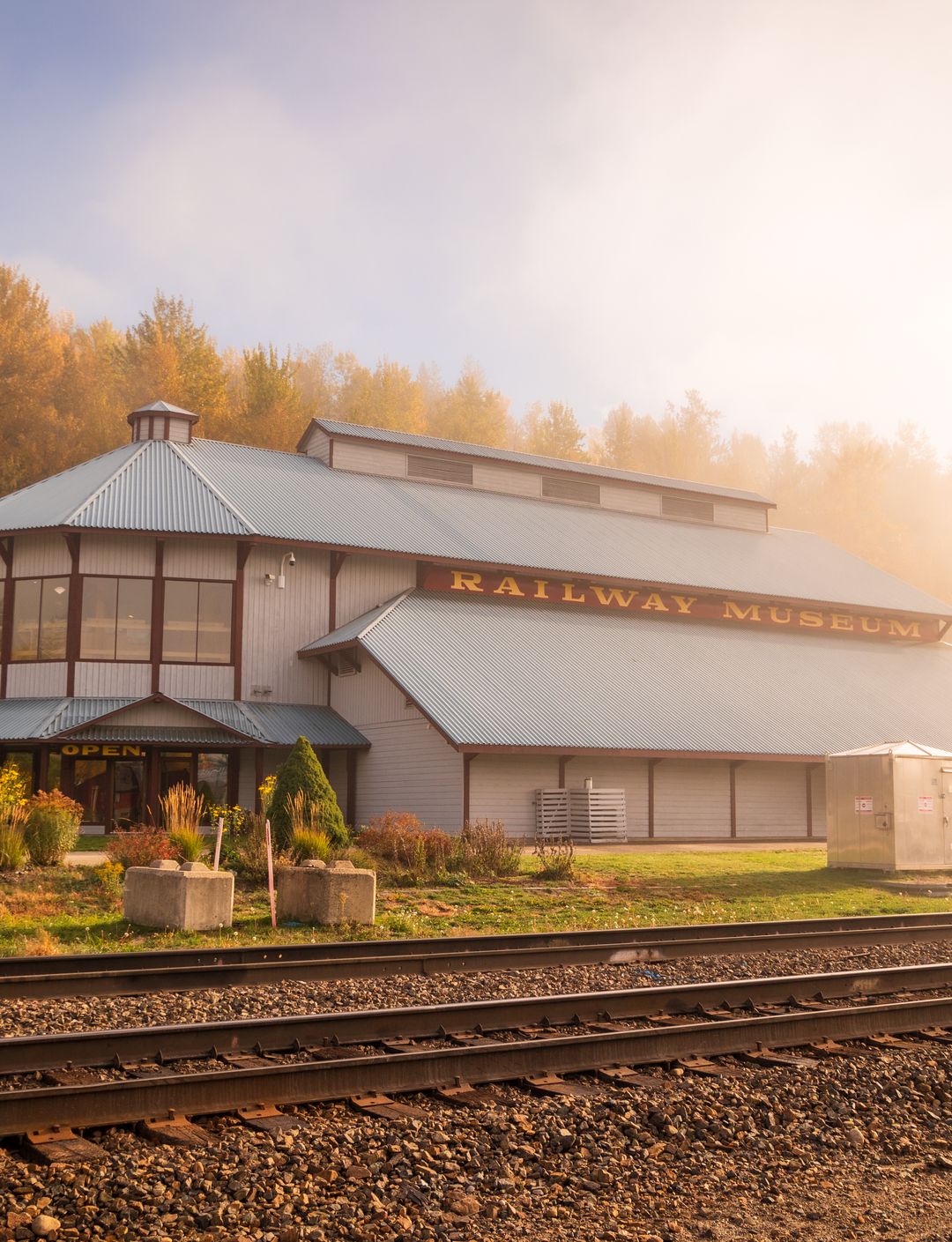 fall coloured trees surronding museum and railway tracks