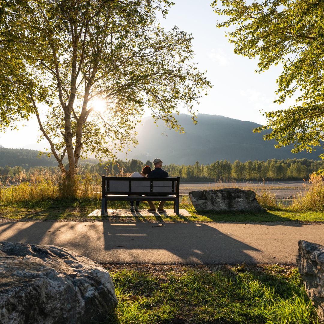 couple sitting on bench along pathway