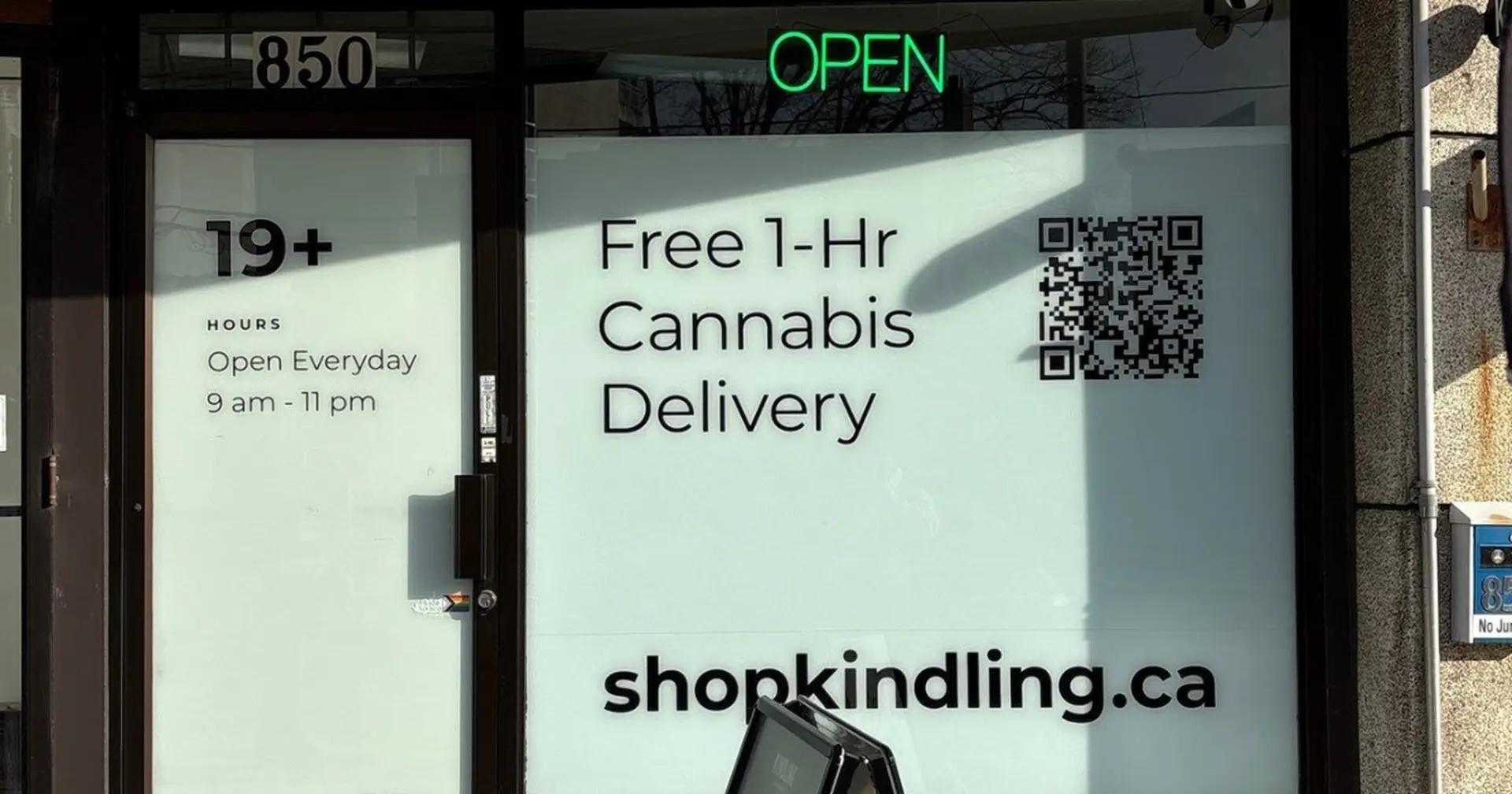 Street-facing door and display window of Kindling’s Leaside cannabis store on Eglinton Ave East