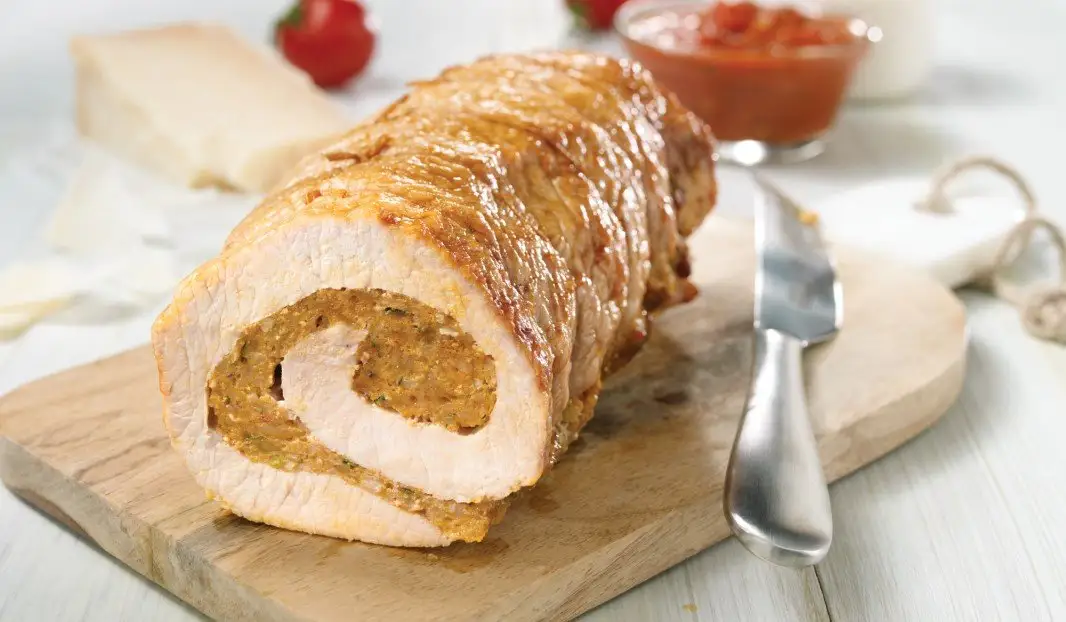 Longe de porc farcie tranchée avec sauce marinara et herbes fraîches
