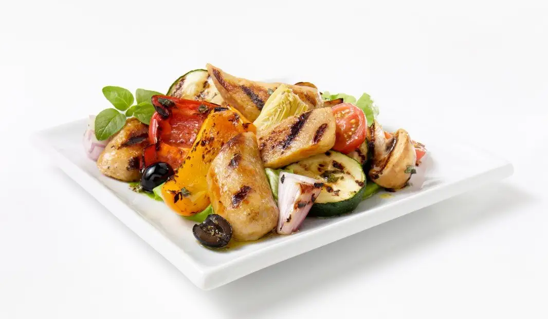 Salade colorée avec saucisses grillées, artichauts et légumes