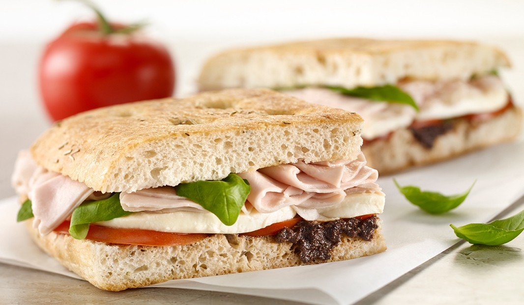 Sandwich focaccia à la dinde, mozzarella, tomate, basilic et tapenade.