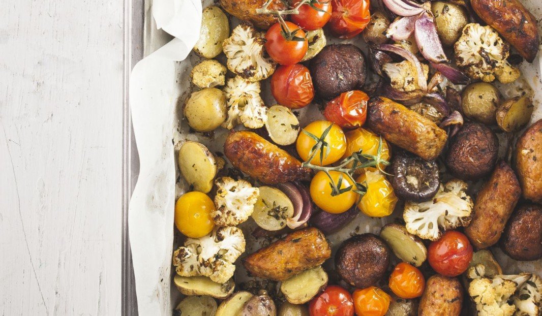 Plat de saucisses italiennes rôties avec légumes et herbes fraîches