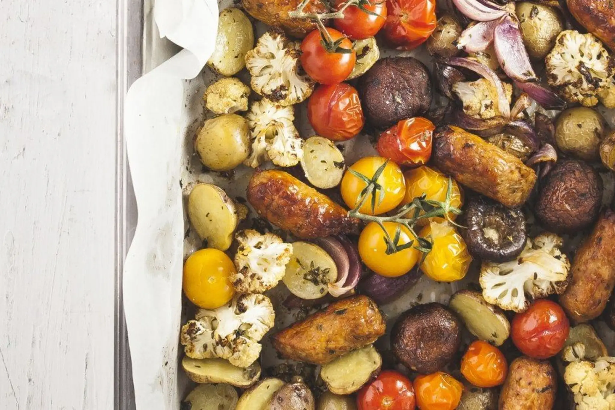 Plat de saucisses italiennes rôties avec légumes et herbes fraîches
