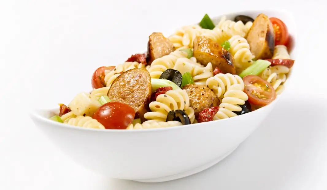 Salade de pâtes fusilis avec saucisses miel et ail, légumes et fromage
