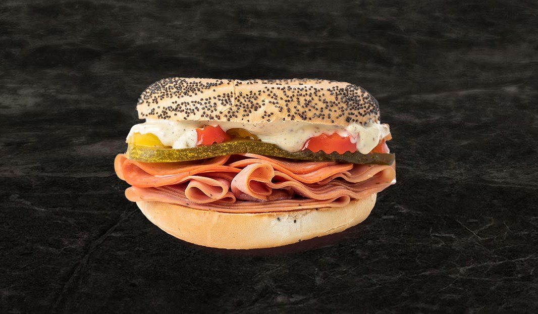 Sandwich polonais au pain aux graines, viande, cornichons et sauce crémeuse.