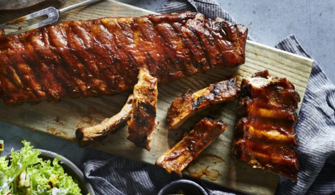 Côtes levées barbecue sur planche avec salade.