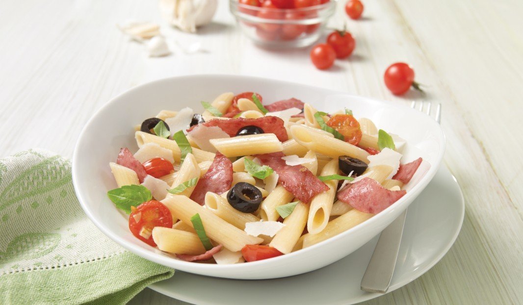 Assiette de penne au salami, basilic frais et copeaux de parmesan