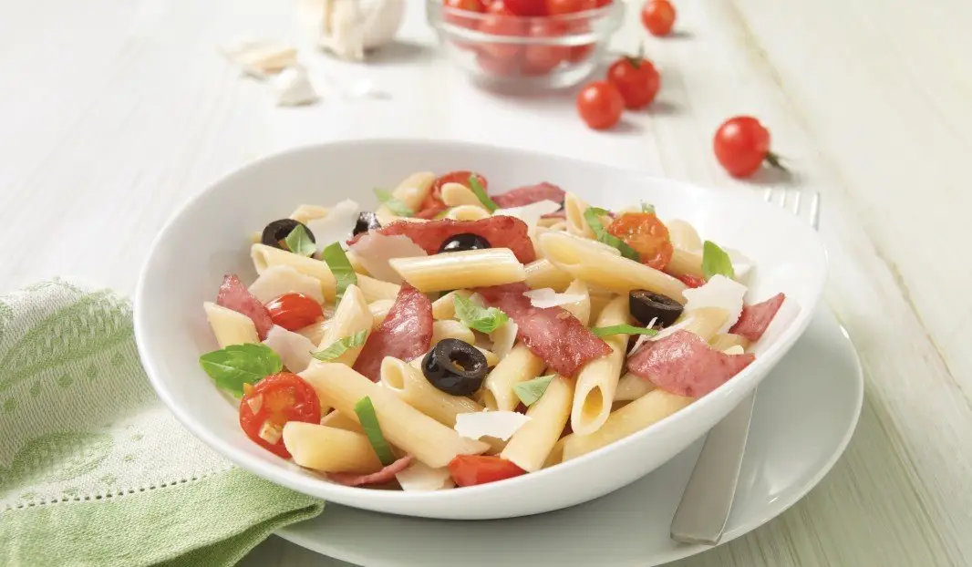 Assiette de penne au salami, basilic frais et copeaux de parmesan
