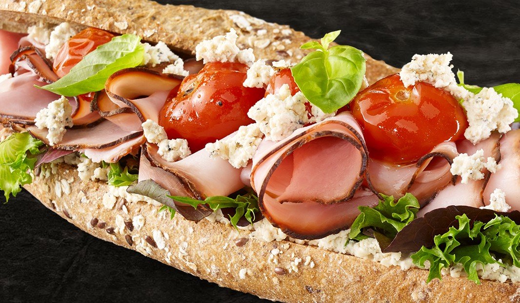 Sandwich baguette au jambon, tomates cerises, fromage et laitue.