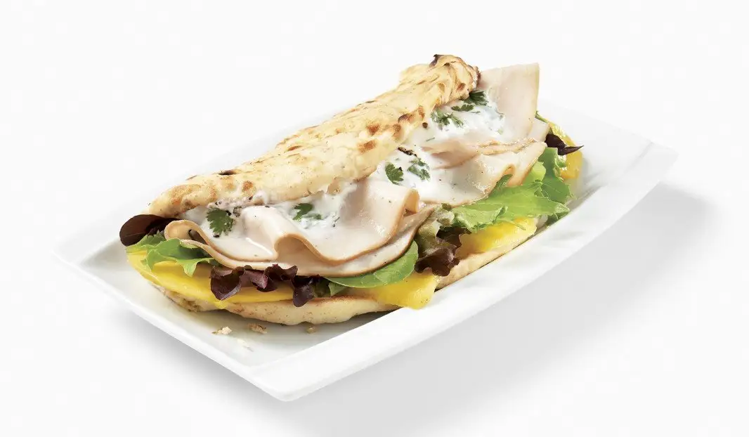 Pita garni de dinde tranchée, mangue et verdures fraîches