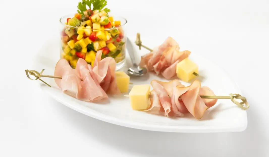 Mini brochettes de jambon et fromage avec salsa colorée aux fruits.