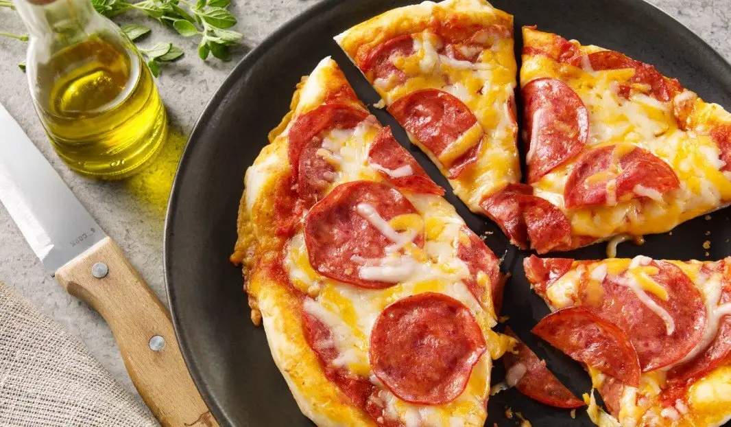 Pizza garnie de pepperoni et fromage fondant sortie du four