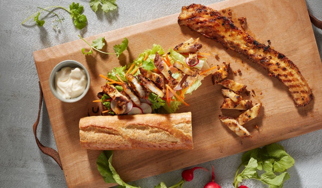 Sandwich au porc grillé avec laitue, carottes râpées et radis