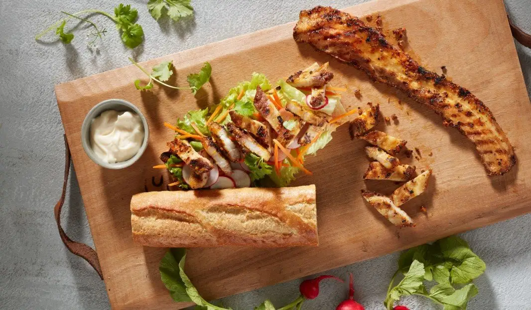Sandwich au porc grillé avec laitue, carottes râpées et radis