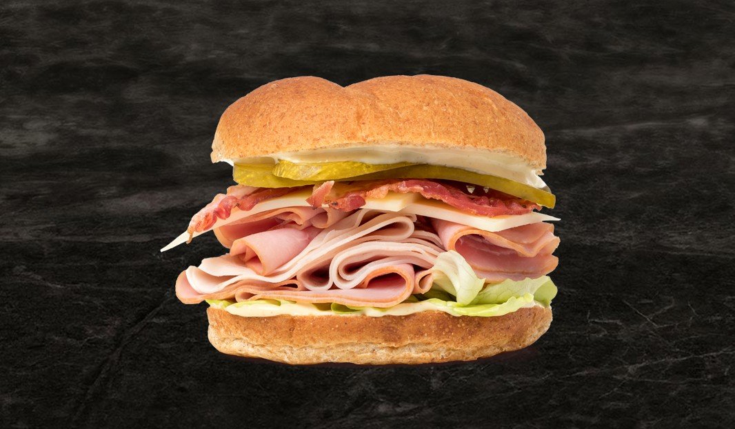 Sandwich au jambon, dinde, bacon, fromage et laitue sur pain Kaiser