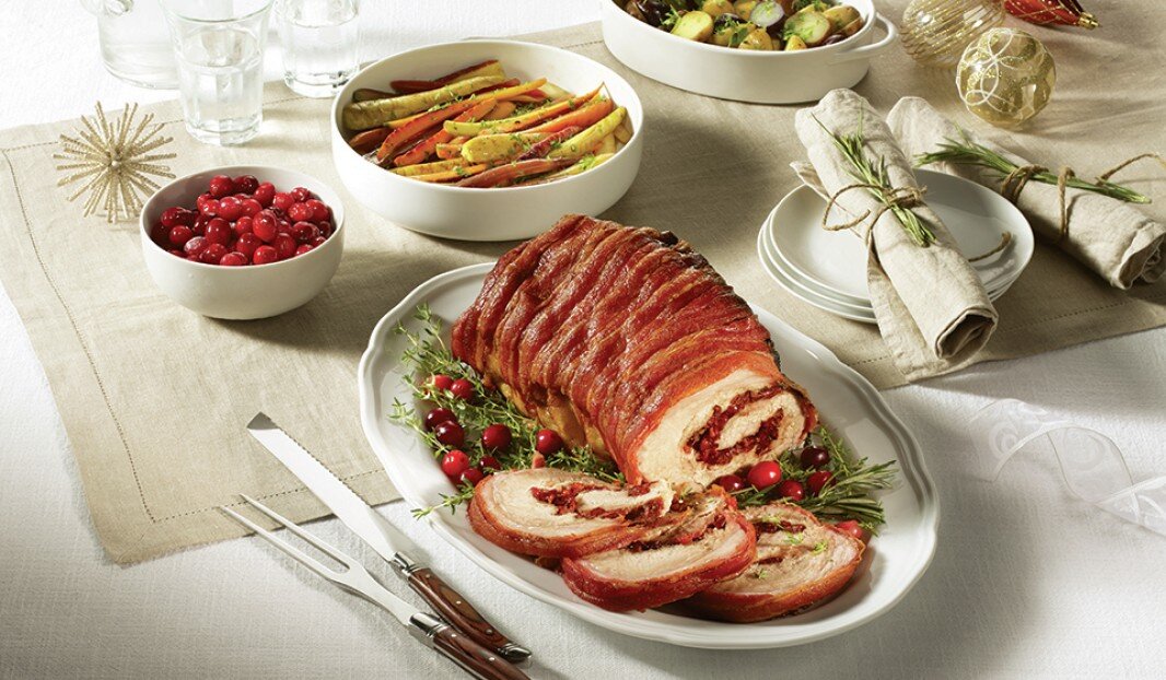 Rôti de viande roulé avec canneberges et herbes sur une table de fête