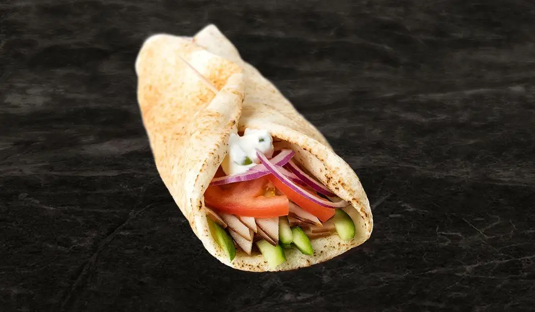 Pita garni de dindon, tomate, concombre, oignon rouge et tzatziki.