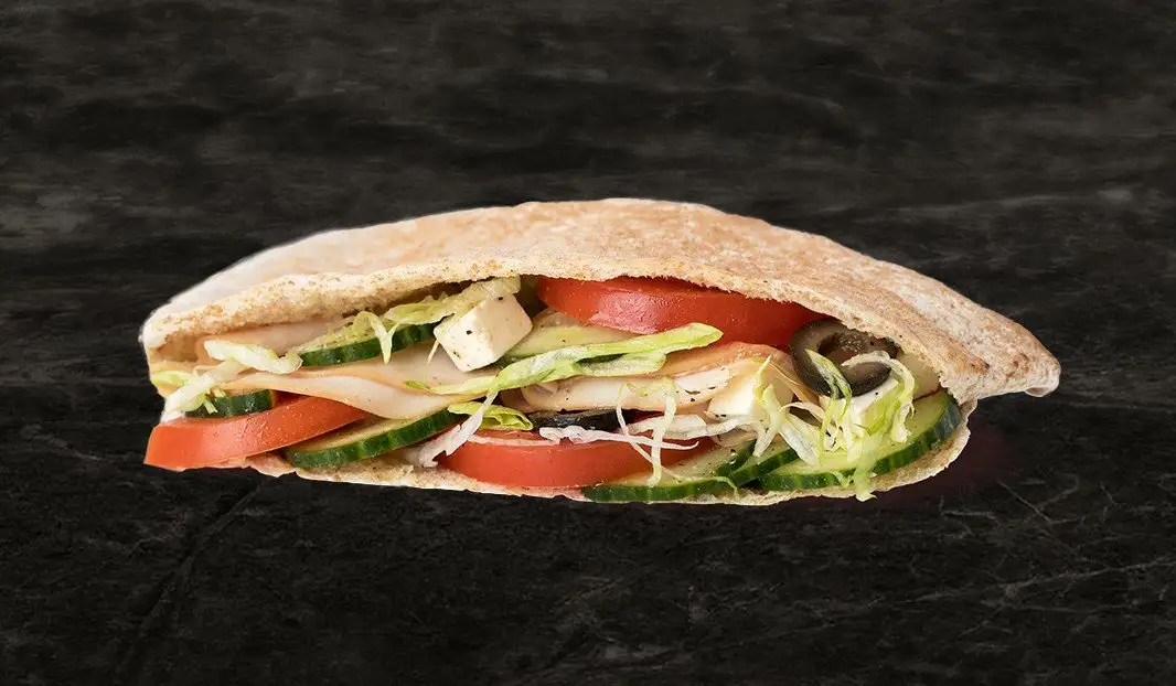 Pita garni de poulet fumé, feta, olives, tomates, concombres et laitue.