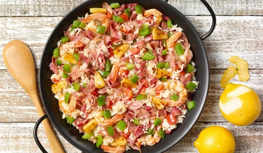 Paëlla colorée avec jambon fumé, crevettes et morceaux d’ananas