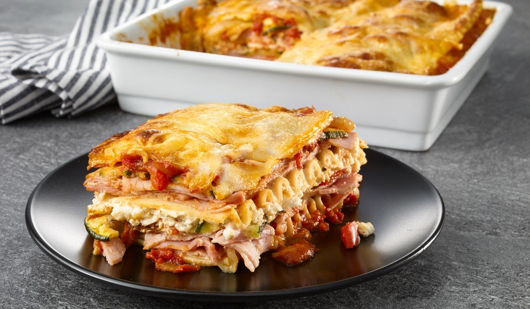Lasagne gratinée au jambon et légumes grillés dans un plat de cuisson