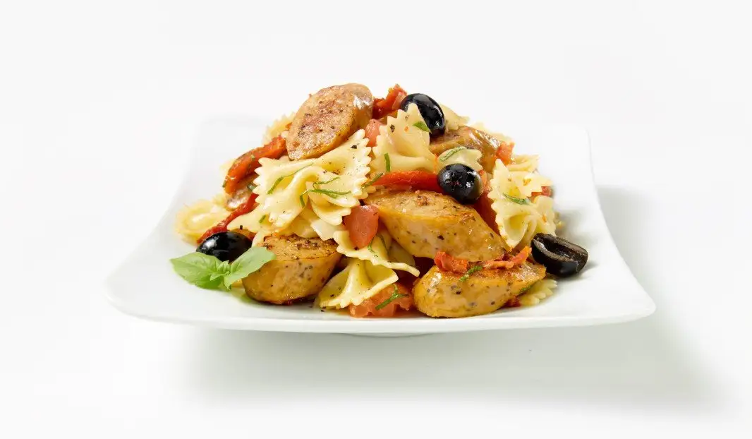 Pâtes sautées avec saucisses italiennes, tomates et olives noires