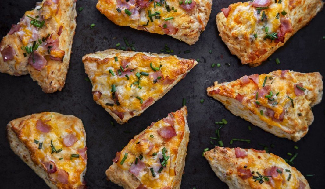 Huit scones triangulaires avec jambon Forêt-Noire et cheddar fondu.