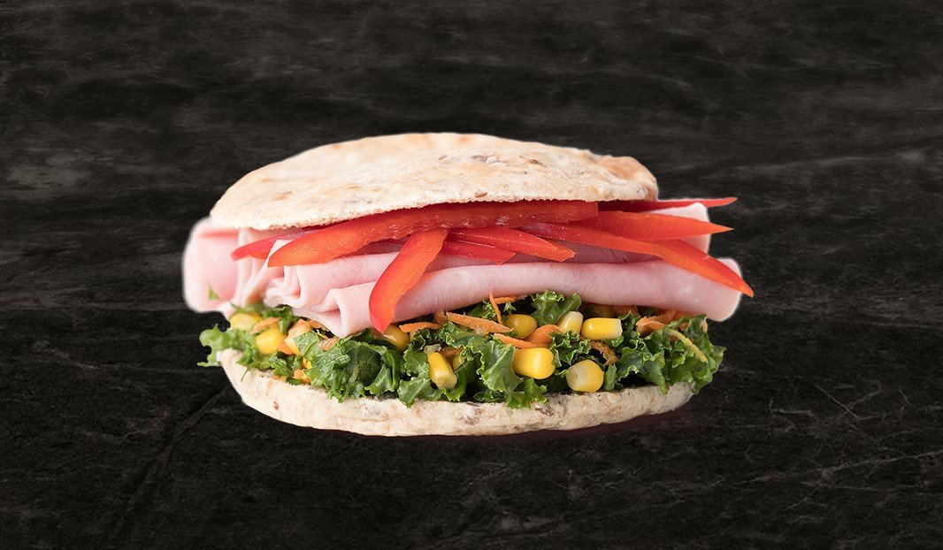 Pita garni de kale, jambon, maïs, carottes et poivrons rouges.
