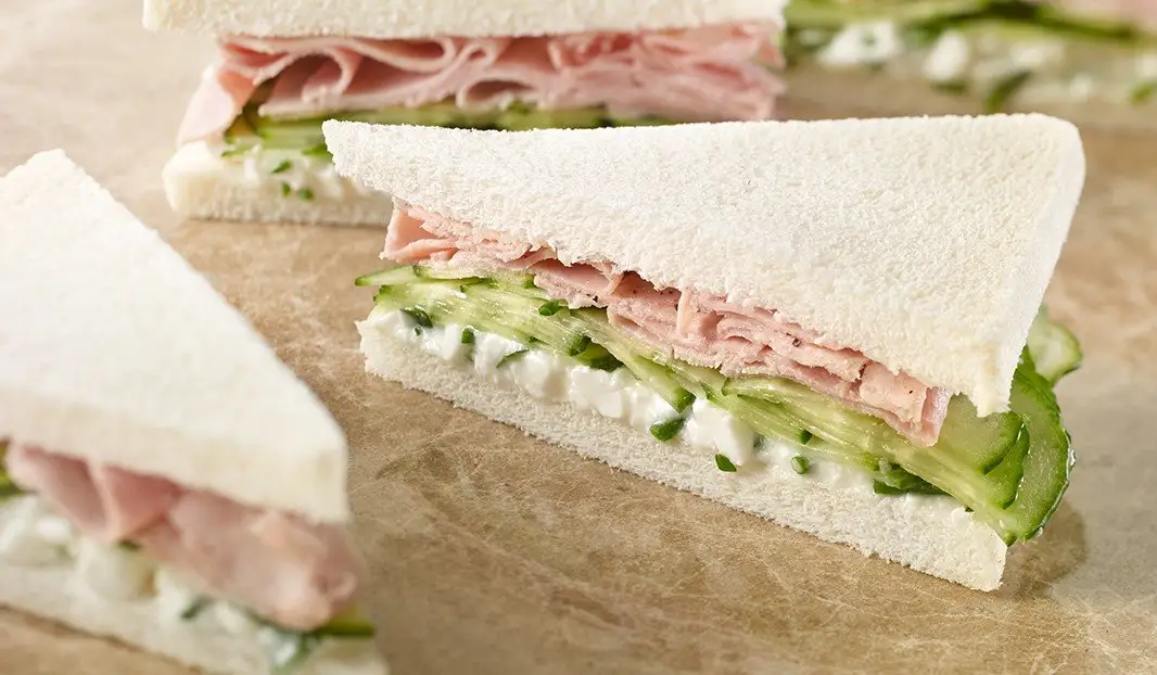 Sandwichs triangles au jambon, concombre et tartinade aux herbes.