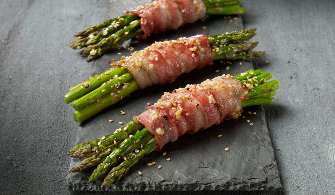 Asperges enroulées de bacon croustillant sur une plaque de cuisson
