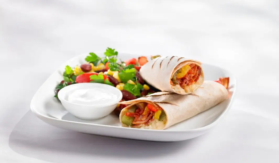 Wrap grillé garni de bacon croustillant, fromage fondu et poivrons colorés