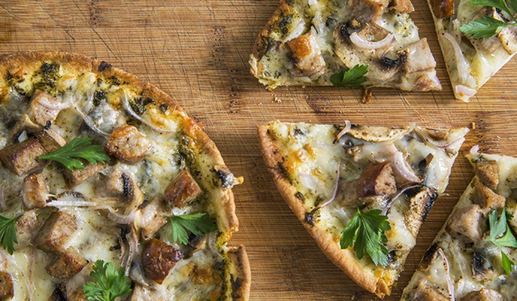 Pizza sur pain pita avec saucisse, légumes et fromage fondu
