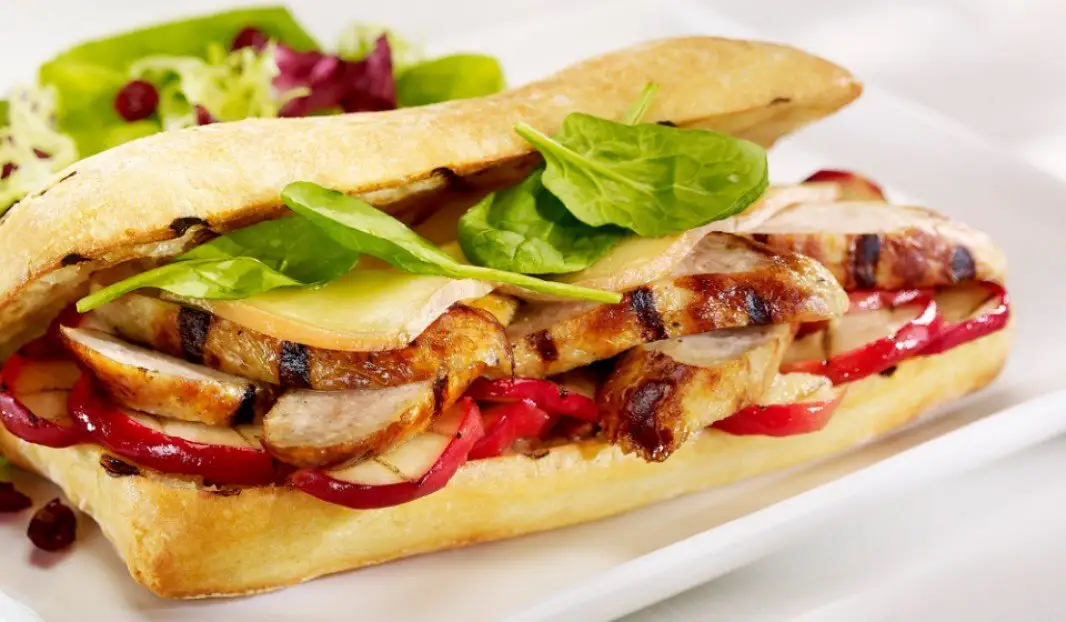 Ciabatta grillée garnie de saucisse, pommes caramélisées et fromage fondant