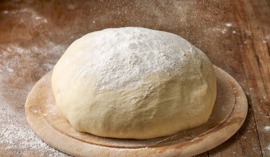 Pâte à pizza sur planche de bois