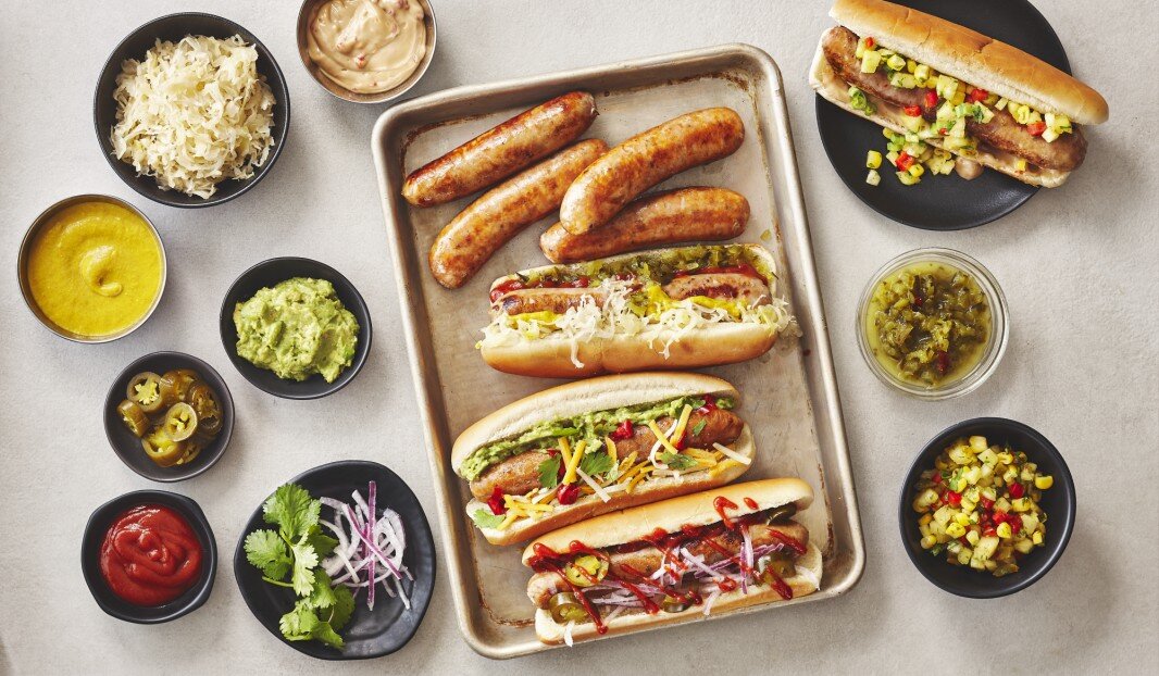 Plateau de saucisses et hot-dogs avec condiments variés.