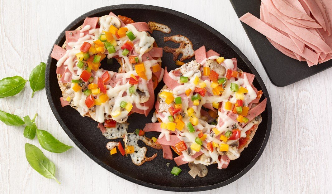 Pizza sur bagel avec bologne, champignons, poivrons et fromage fondu